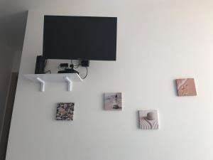 una tv appesa a un muro con delle foto di Villa Azzurra a Marina di Pescoluse