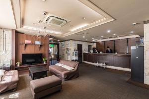 a living room with a couch and a bar at Hotel Wing International Izumi in Izumi