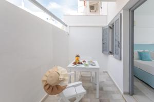 a small white room with a table and a bed at Ippokampos Town Apartments in Naxos Chora