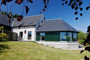 a white house with a black roof and windows at Belforte House Holiday Home in Inverness