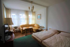 - une chambre avec un lit, une table et un canapé dans l'établissement Dom wypoczynkowy Szarotka&Krokus, à Międzyzdroje