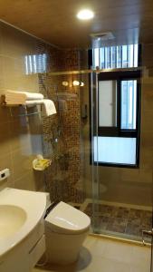 a bathroom with a toilet and a glass shower at Dolphin Love Homestay in Jian