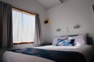 Schlafzimmer mit einem großen Bett und einem Fenster in der Unterkunft Euroa Caravan Park in Euroa