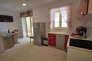 a kitchen with a sink and a refrigerator and a window at Apartment Carlitos in Karlobag