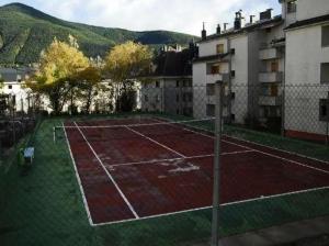 a tennis court in front of a building at Apartamento MODESTO en las montañas del pirineo aragonés en Alquiler Altruista ECONÓMICO in Villanúa