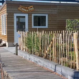 a wooden fence in front of a building at Costa del Twel in Uitwellingerga