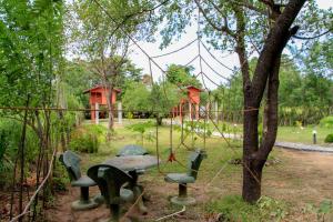 a park with a table and chairs and a playground at Sigiri Royal Point Tree House in Sigiriya