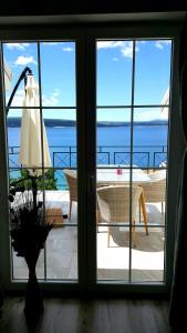 a door with a view of the ocean from a balcony at Apartments Villa Harmonie - Adults Only +14 in Crikvenica