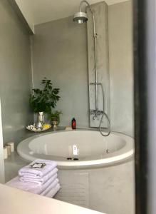 La salle de bains est pourvue d'une baignoire avec miroir et de serviettes. dans l'établissement Stylish penthouse with Acropolis and 360 view, à Athènes