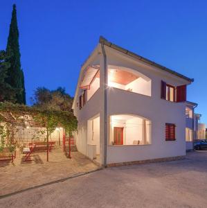 a large white building with a table and benches at Apartment Bagaric in Stari Grad