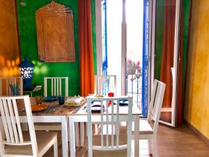 a dining room with a table and four chairs at Cortile Sant'Agostino - Suites & Rooms in Mazara del Vallo