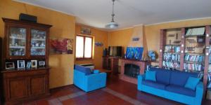 a living room with two blue chairs and a fireplace at Giardino 21 Marzo in Vico Equense