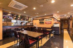 a restaurant with tables and chairs and a bar at Hotel Wing International Kumamoto Yatsushiro in Yatsushiro