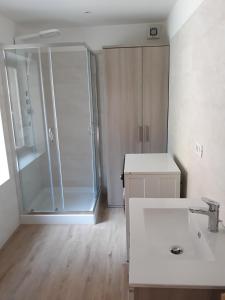 ein Badezimmer mit Dusche und weißem Waschbecken in der Unterkunft Al Becalen in Livinallongo del Col di Lana