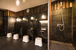 a bathroom with three urinals and a shower at Hotel Wing International Kumamoto Yatsushiro in Yatsushiro