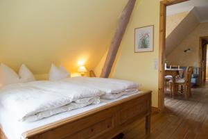 a bedroom with a large bed with white sheets at Ostsee-Landhaus in Rerik