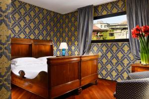 een slaapkamer met een houten bed en een raam bij Hotel Pierre Milano in Milaan