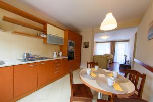 a kitchen and dining room with a table and chairs at Villa Turris in Muszyna