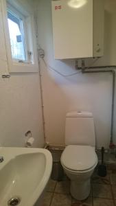 La salle de bains est pourvue de toilettes blanches et d'un lavabo. dans l'établissement Nix at Gammel Rye, à Ry