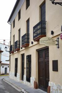 un edificio con balcones y una puerta en una calle en Casa Rural Aromas de la Manchuela, en Alborea
