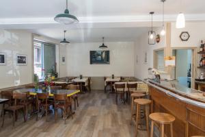 a restaurant with tables and chairs and a bar at Hotel Solomiac in Grand-Vabre