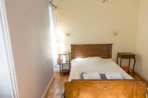 1 dormitorio con 1 cama de madera y 2 toallas en Hotel Solomiac, en Grand-Vabre