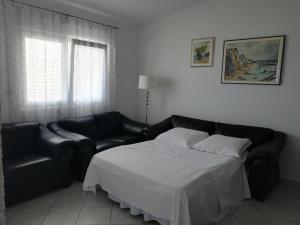 a bedroom with a bed and a couch at LARA & VITO in Metajna