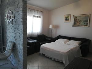 a bedroom with a bed and a brick wall at LARA & VITO in Metajna
