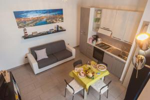 a kitchen and a living room with a table and a couch at Casa Vacanze Belleville in Trani +16 photos
