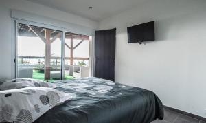 1 dormitorio con 1 cama y TV de pantalla plana en T2 vue sur le golfe d'Ajaccio, en Porticcio