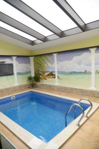 a swimming pool in a house with a painting on the wall at Hotel Emocia in Natakhtari