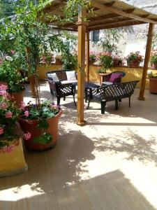 un patio con mesa, sillas y flores en Funtanedda, en Teti