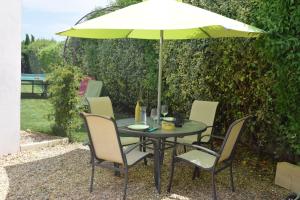 MaillaneにあるLoft Le Mistral avec SPA extérieur en saisonの庭園の傘下のテーブルと椅子