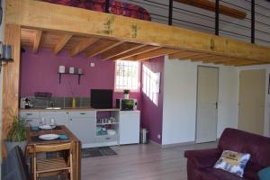 a living room with a loft with purple walls at Loft Le Mistral avec SPA extérieur en saison in Maillane +14 photos