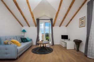 a living room with a blue couch and a tv at Otium in Kaštela