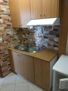 a sink in a kitchen with a stone wall at Hotel Filoxenia in Ligia