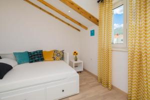 a bedroom with a white bed and a window at Otium in Kaštela