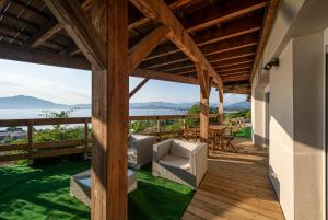 una terraza de madera con sillas, una mesa y el océano en T2 vue sur le golfe d'Ajaccio, en Porticcio