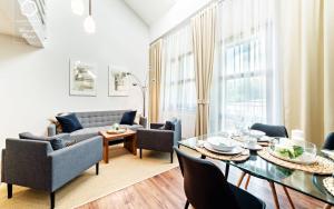 a living room with a table and a couch at Wonder Home - Apartamenty Residence Karpacz tuż przy stoku narciarskim i przy Głównym Szlaku Sudeckim in Karpacz