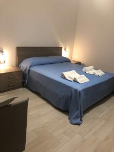 a bedroom with a blue bed with two towels on it at Casa Profumi di Puglia in Castellana Grotte
