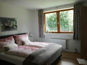 a bedroom with a bed with a pink and white blanket at Ferienhaus Bella Vista in Presseggersee