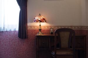 um quarto com uma secretária com um candeeiro e uma cadeira em CHRES em Kochi