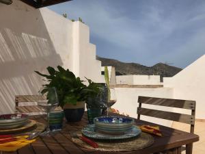 a wooden table with plates and bowls on it at Casa Torre di Ligny in Favignana