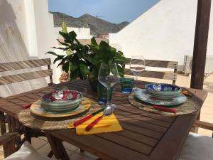 a wooden table with plates and dishes on it at Casa Torre di Ligny in Favignana