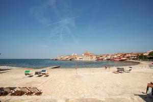 a beach with chairs and the water and buildings at Downtown beach apartments in Umag