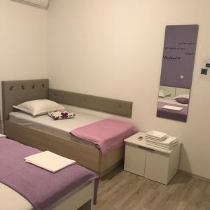 a small room with two beds and a mirror at Apartments Nela in Jesenice