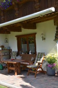 un patio con 2 sillas y una mesa y sillas de madera. en Haus Marco, en Neustift im Stubaital