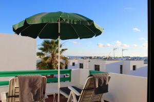 - un parasol vert installé au-dessus d'un balcon dans l'établissement Ocean & Fire, à Playa Blanca