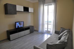 a living room with a couch and a tv at Appartamento nel cuore di Sori in Sori