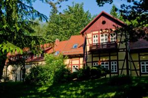 ein großes Haus mit rotem Dach in der Unterkunft Hotel Habichtstein in Alexisbad